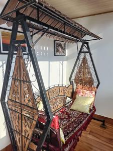 una cama en una habitación con una estructura de hierro en Sat Chit Ananda bhavan, en Darjeeling