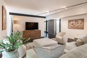 uma sala de estar com um sofá, cadeiras e uma TV em Pass the Keys Bond-villain Style Home with Panoramic Views em Enborne