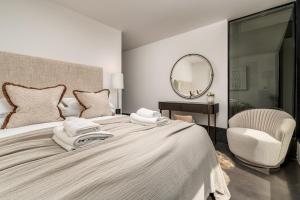 um quarto com uma cama grande, um espelho e uma cadeira. em Pass the Keys Bond-villain Style Home with Panoramic Views em Enborne