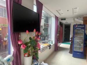 a flat screen tv hanging on a wall with flowers at Grand Ireland hotel in Cat Ba