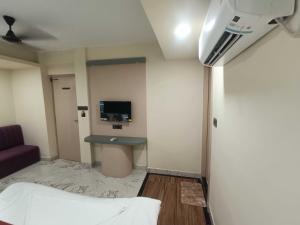 a room with a bed and a desk and a tv at Hotel O KOLKATA SEVEN INN LLP in Salkhia