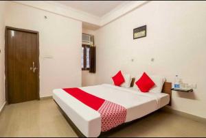 a bedroom with a large bed with red pillows at Hotel O Unique Stay Inn in Bādshāhnagar