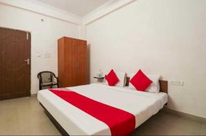 a bedroom with a large bed with red pillows at Hotel O Unique Stay Inn in Bādshāhnagar