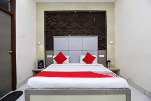 a bedroom with a large bed with red pillows at Hotel O Unique Stay Inn in Bādshāhnagar