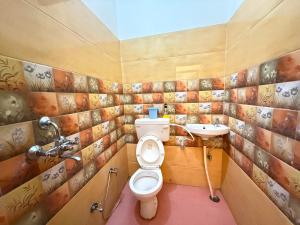a bathroom with a toilet and a sink at Hotel O Sri in Banāras Cantonment