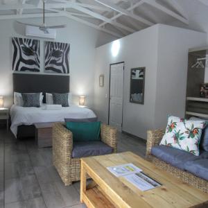 a room with a bed and a couch and a table at Villa de Leeu, Perfect for Two in Marloth Park +69 photos