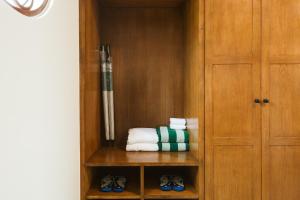 a cabinet with towels and shoes in a room at Sugar Marina Resort-LAGOON-Villas, Naiyang Beach in Nai Yang Beach