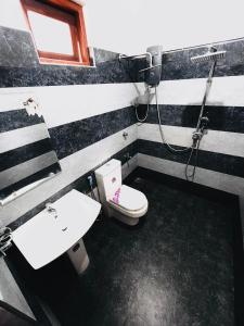 a bathroom with a toilet and a sink and a shower at Monkey Garden Hotel in Polonnaruwa +16 photos
