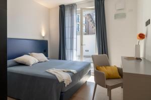 a bedroom with a blue bed and a chair at Vela Azzurra Holiday Home in Grottammare