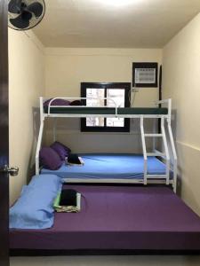 a room with two bunk beds in a room at El Nido Cabugao Loudge in El Nido