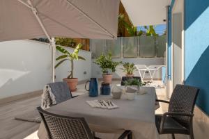 a table with chairs and an umbrella on a patio at Vela Azzurra Holiday Home in Grottammare