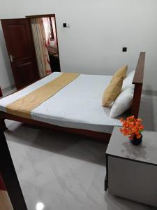 Un dormitorio con una cama y una mesa con una flor en Spring View Holiday Home - Villa, en Badulla