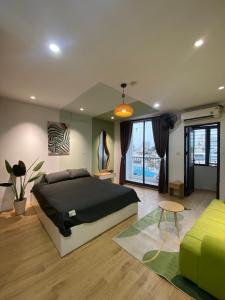 a bedroom with a large bed and a green couch at Love Paradise Hotel Hà Nội in Hanoi