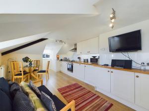 a living room with a couch and a tv on the wall at Sea Loft Penthouse - Whitby in Whitby +7 photos