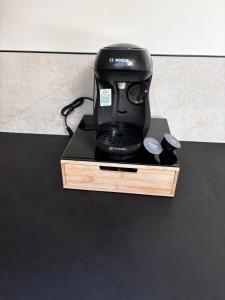 a black coffee maker sitting on top of a table at Appartement cosy une chambre in Charnècles