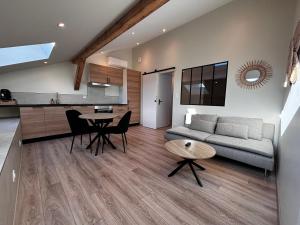 a living room with a couch and a table at Appartement cosy une chambre in Charnècles