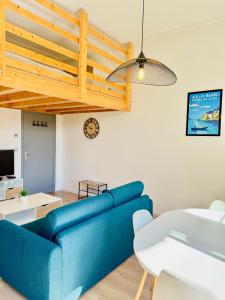 a living room with a blue couch and a table at Le Bernascon - Mezzanine et Calme in Aix-les-Bains