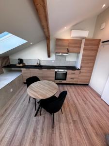 a kitchen with a table and chairs in a room at Appartement cosy une chambre in Charnècles +4 photos