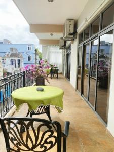 a green table and chairs on a balcony at Belle Mare Apartment in Belle Mare