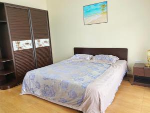 a bedroom with a bed with a blue and white comforter at Belle Mare Apartment in Belle Mare