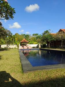 une piscine dans la cour d'une maison dans l'établissement Homestay Retreat, à Uluwatu 7 autres photos
