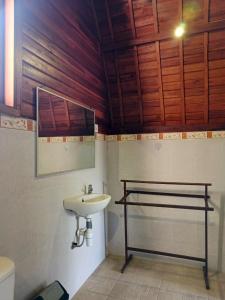 une salle de bain avec un lavabo et un miroir dans l'établissement Homestay Retreat, à Uluwatu