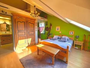 a bedroom with a bed and a green wall at Le Belvédère : chambres et table d'hôtes in Montmélian