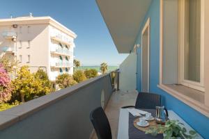 a table and chairs on the balcony of a building at Vela Azzurra Holiday Home in Grottammare