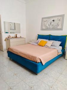 Una gran cama azul en una habitación blanca en A un passo dal cuore, en Mesagne