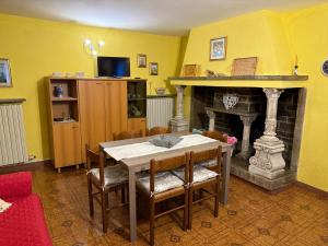 a dining room with a table and a fireplace at Il Camino in Anzino