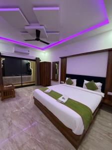 Un dormitorio amplio con una cama grande y luces moradas. en Braham Niwas Resort, en Pushkar