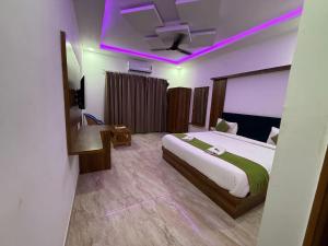 a bedroom with a large bed with a purple lighting at Braham Niwas Resort in Pushkar