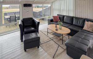 ein Wohnzimmer mit Sofa, Stühlen und einem Tisch in der Unterkunft Amazing Home In Ebeltoft With Sauna in Ebeltoft