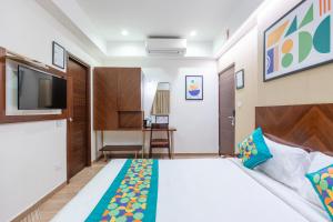 a hotel room with a bed and a tv at Treebo Flora Embassy in Chennai +37 photos