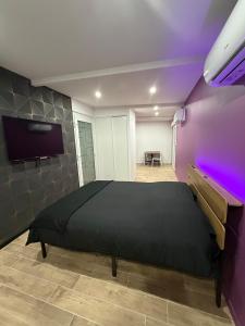 a bedroom with a bed and a purple wall at Les secrets de l Esch in Jezainville