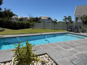 a swimming pool in the backyard of a house at THE SURF AND GOLF HUIS Solar Power in St Francis Bay