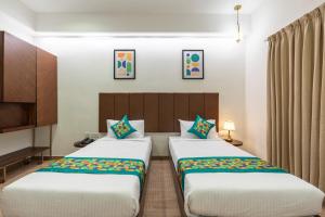 two beds in a hotel room with two beds at Treebo Flora Embassy in Chennai +38 photos