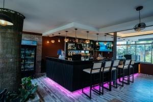 a bar in a restaurant with purple lights at Murugano Village Hotel in Taba