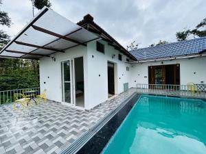 a villa with a swimming pool and a house at Serene Pool Villa-Coffee Estate Stay,Mudigere in Mudigere