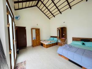 a bedroom with two beds and a blue couch at Serene Pool Villa-Coffee Estate Stay,Mudigere in Mudigere