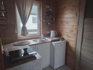Una pequeña cocina con fregadero y lavadora. en Bursztynek Łunowa, en Świnoujście 36 fotos más