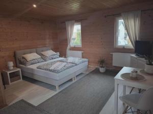 Un dormitorio con una cama en una pared de madera. en Bursztynek Łunowa, en Świnoujście