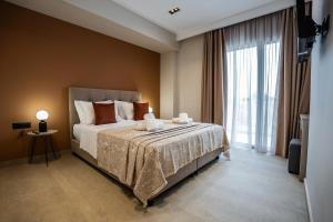 a bedroom with a bed and a large window at Phōs, Light Modern Living in Gaïtánion