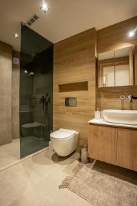 a bathroom with a toilet and a sink and a shower at Phōs, Light Modern Living in Gaïtánion