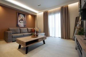 a living room with a couch and a coffee table at Phōs, Light Modern Living in Gaïtánion