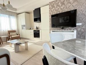 een woonkamer met een tafel en een tv aan de muur bij 91 sqm luxury apartment with double view in Istanbul