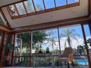 een kamer met grote ramen en een tafel en stoelen bij Hillside Retreat with Pool in Flagstaff Hill