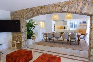 サント・マキシムにあるLovely luxury villa with garden and private poolの石壁のリビングルーム(ダイニングテーブル付)