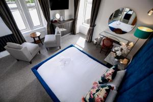 Una sala de estar con un sofá y un espejo. en Lovat Hotel, en Perth