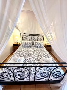 a bedroom with a black and white bed with curtains at Torre Picada Duplex in Port de Soller +35 photos